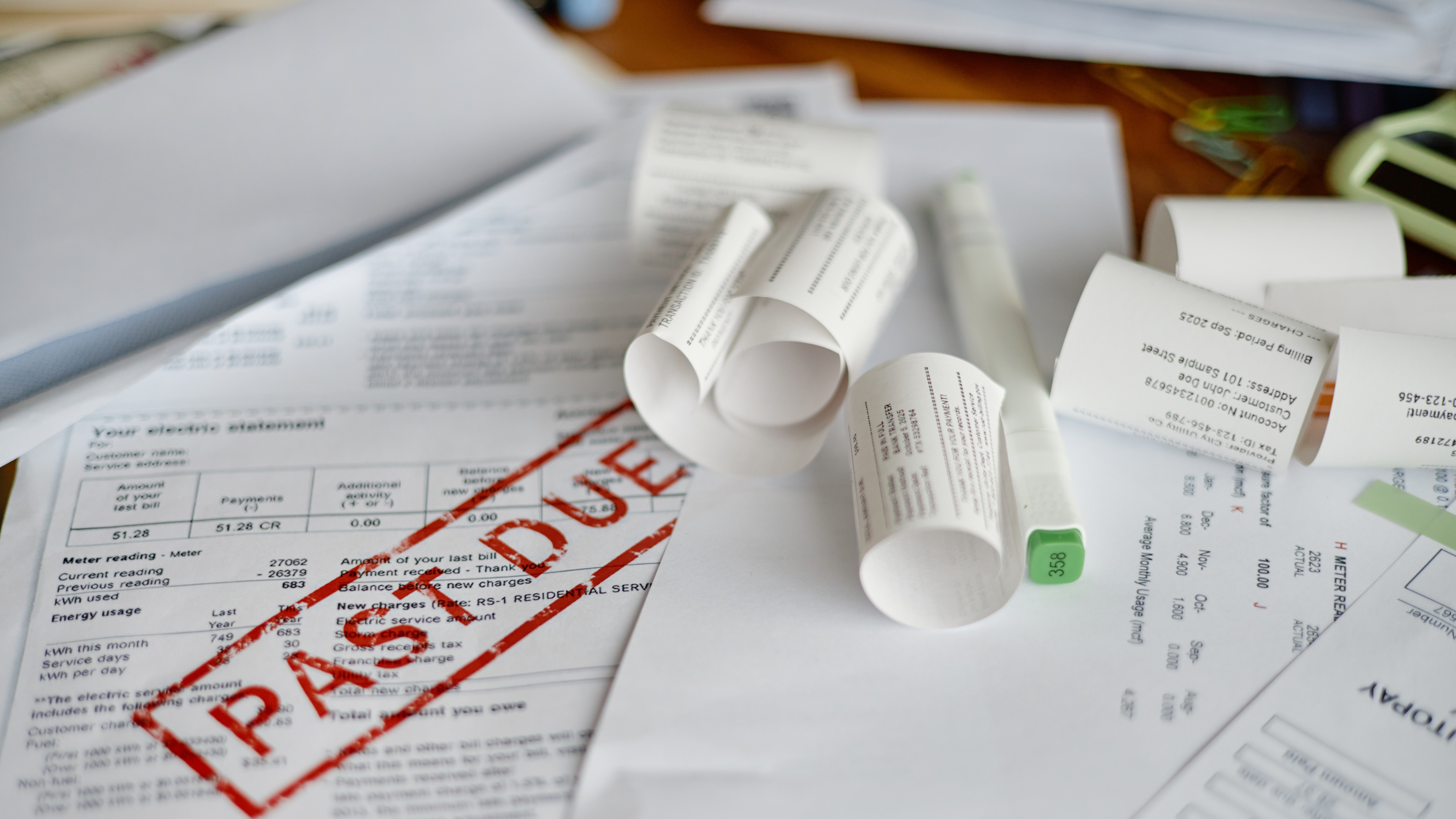 Closeup of Unpaid Utility Bills and Invoices Being Analyzed for Payment